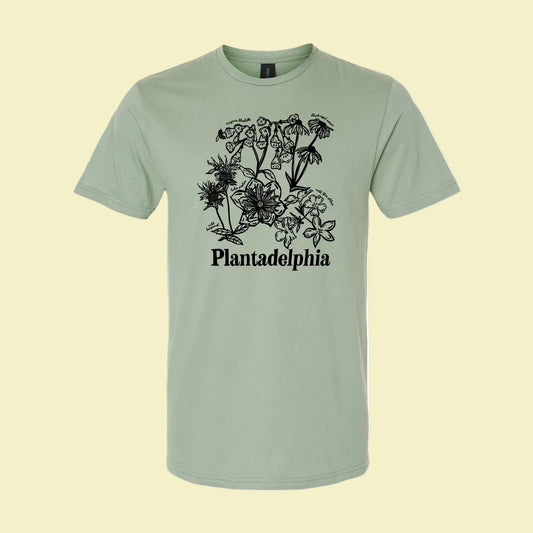 light green t-shirt with black floral design and 'Plantadelphia' text on a yellow background