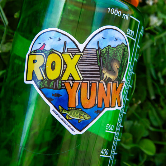 Green bottle with 'Rox Yunk' label featuring a heart design on a grassy background