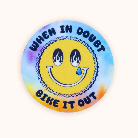Sticker with smiley face and text 'When in doubt, bike it out' on a tie-dye background.