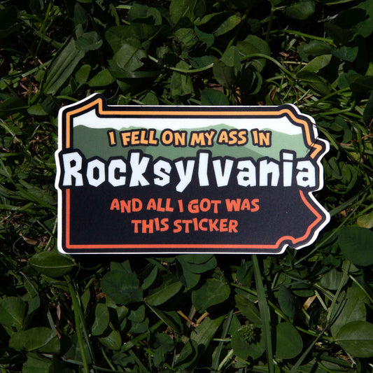 Sticker with text 'I fell on my ass in Rocksylvania and all I got was this sticker' on grass