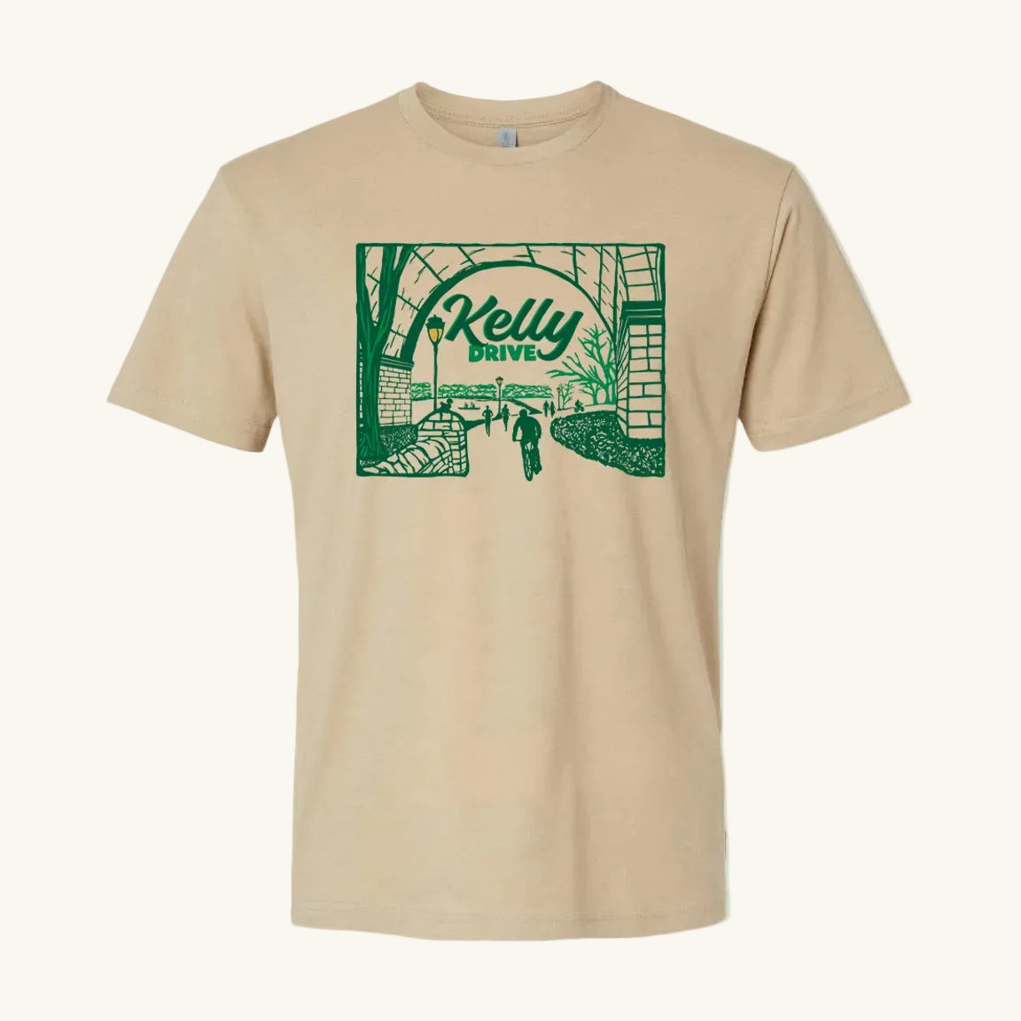 Beige t-shirt with 'Kelly Drive' design featuring a scenic view or bikers, runners and rowers on a trail, on a light blue background. 
