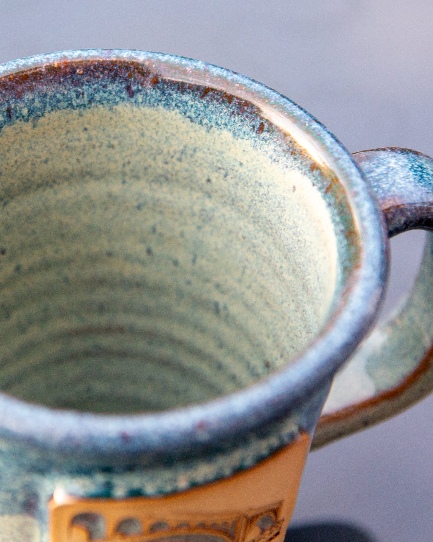 Close-up of a ceramic mug with a textured interior and handle.