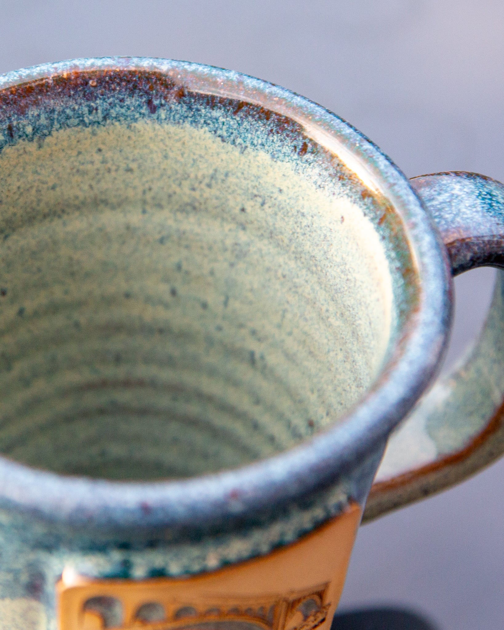 Close-up of a ceramic mug with a textured interior and handle.