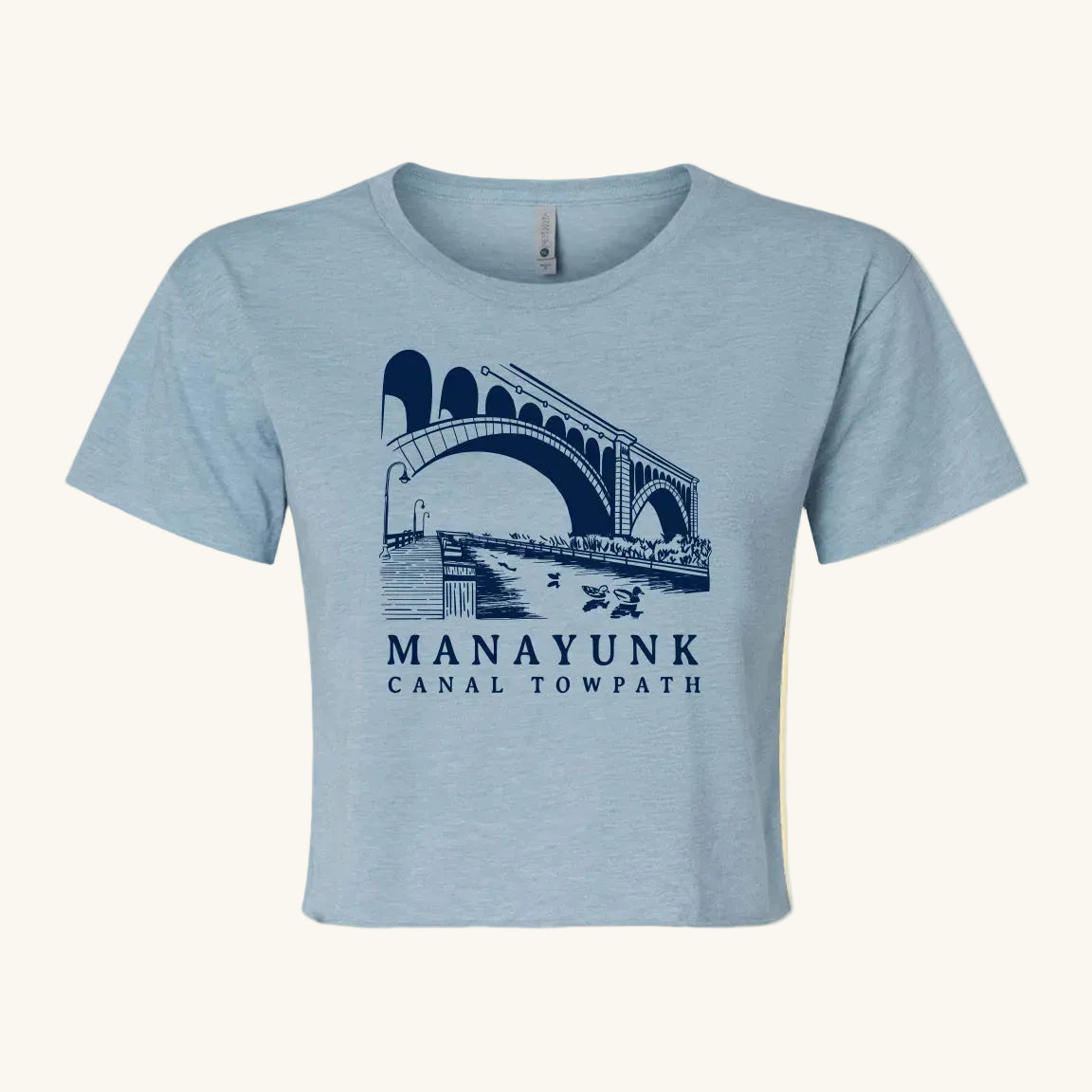 light blue crop top with a bridge and nature graphic and 'Manayunk Canal Tow Path' text.