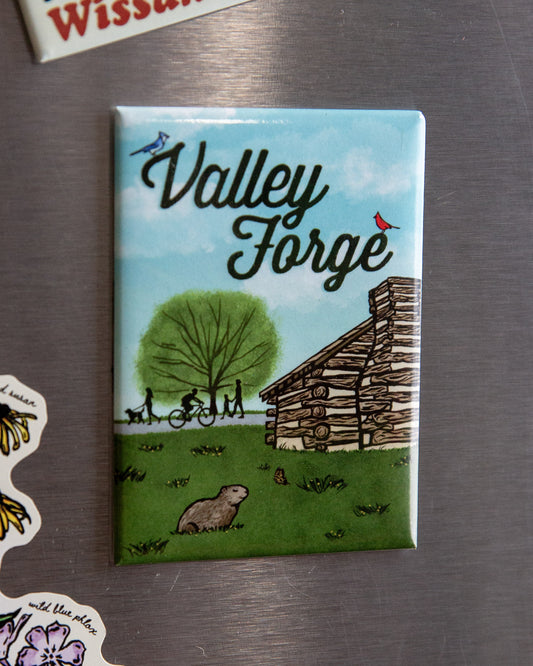 Fridge magnet with 'Valley Forge' design featuring a cabin and nature on a metallic surface.