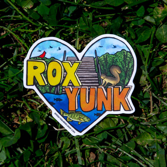 Heart-shaped sticker with 'ROX YUNK' text and nature-themed illustrations on grass