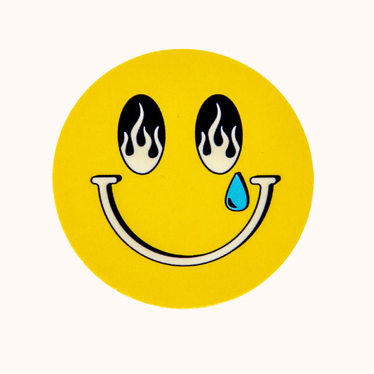 Smiley face with flames for eyes and a blue teardrop on a yellow background