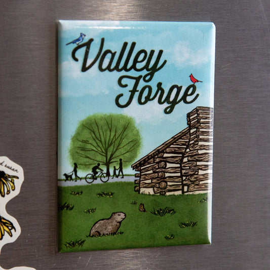 Fridge magnet with 'Valley Forge' design featuring a cabin and nature on a metallic surface.