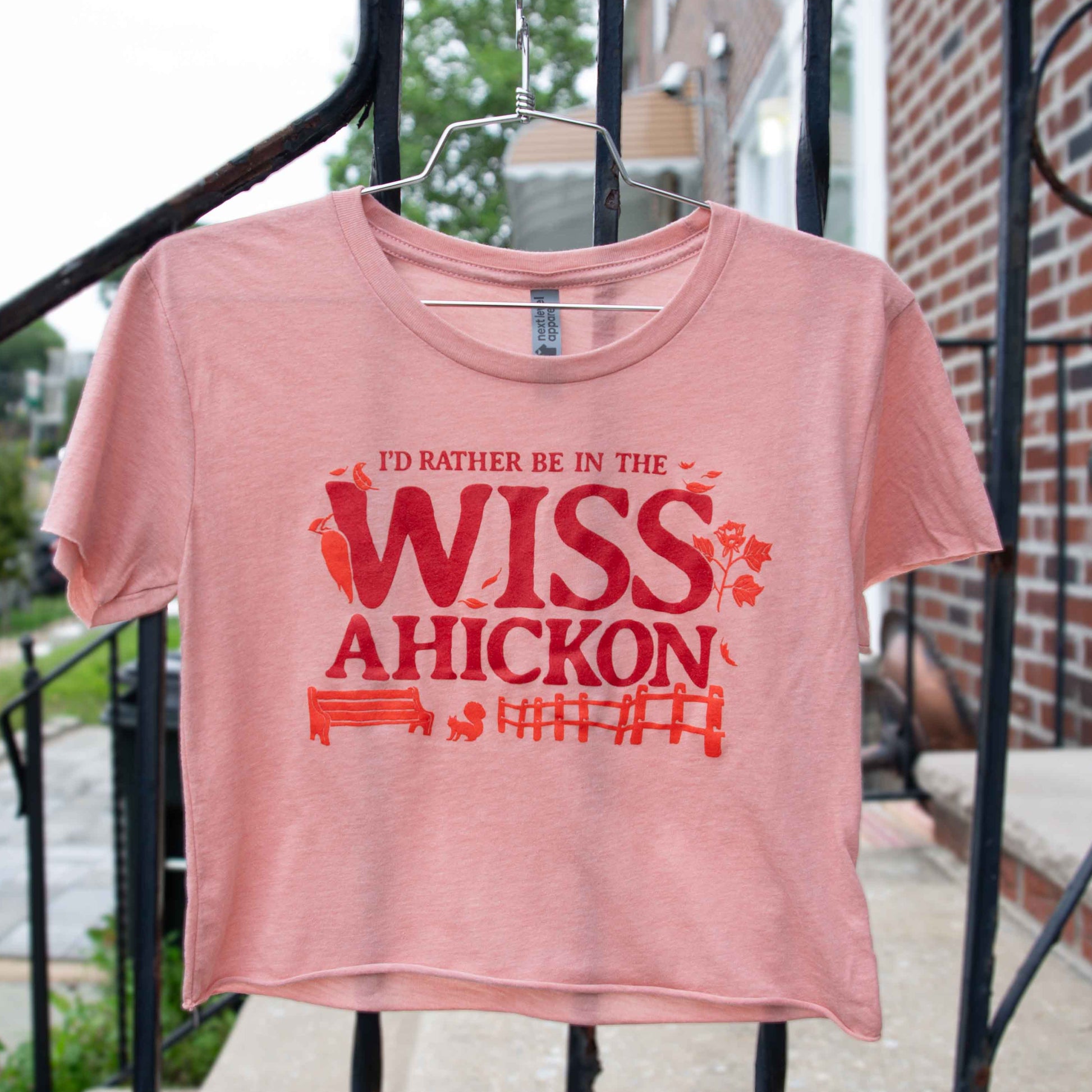 Pink crop with red text 'I'd Rather Be In The Wissahickon' on a hanger.