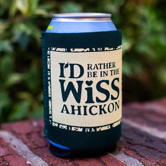 Can with a sleeve labeled 'I'd Rather Be in the Wissahickon' on a brick surface with greenery in the background