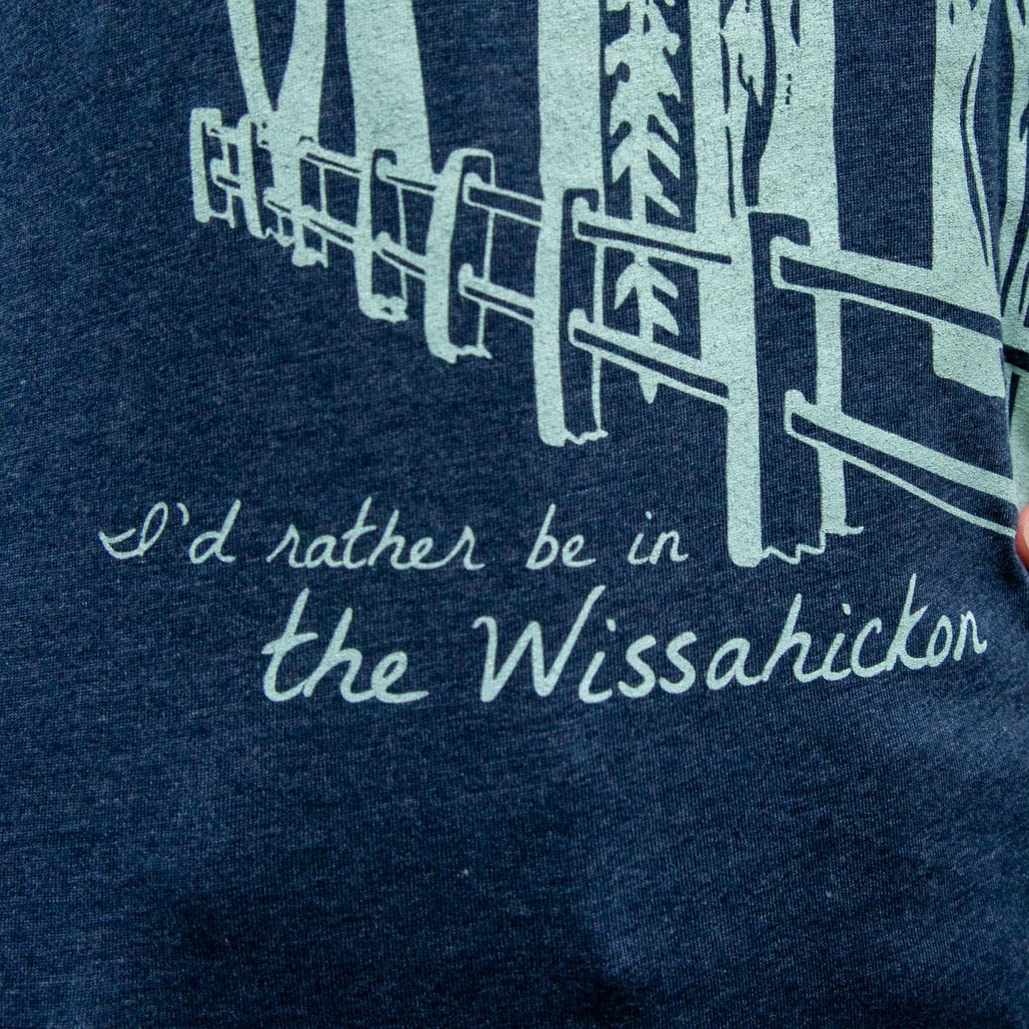 Navy blue t-shirt with light green graphic of a fence in a forest and text 'I'd rather be in the Wissahickon'.