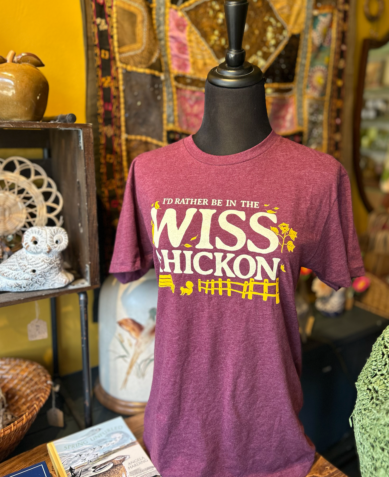 Maroon t-shirt with 'I'd Rather Be In The Wisschickon' text on a mannequin against a decorative background.